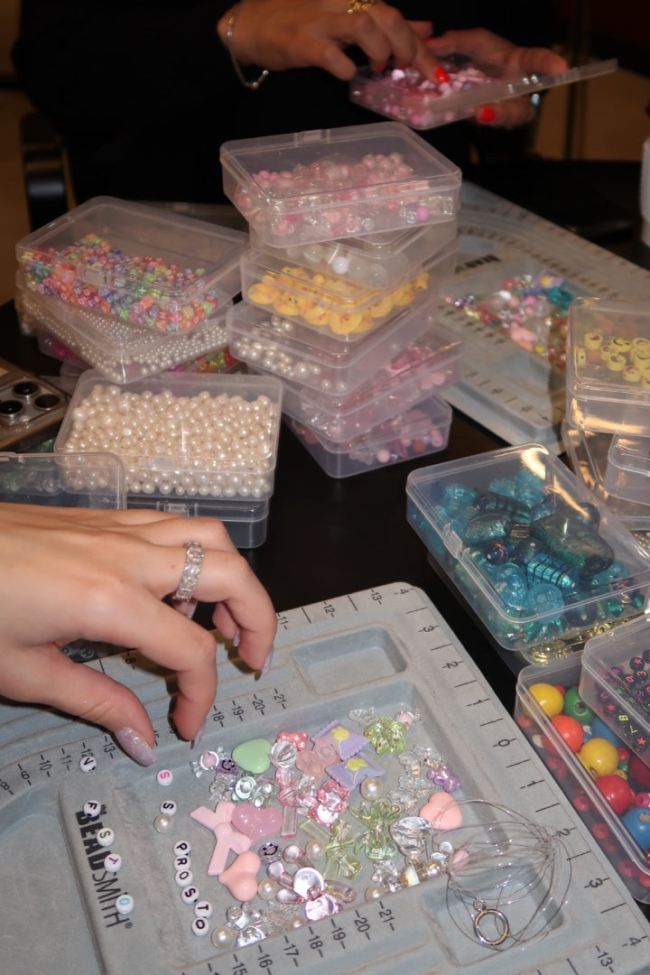 A person choosing beads from a selection of beads